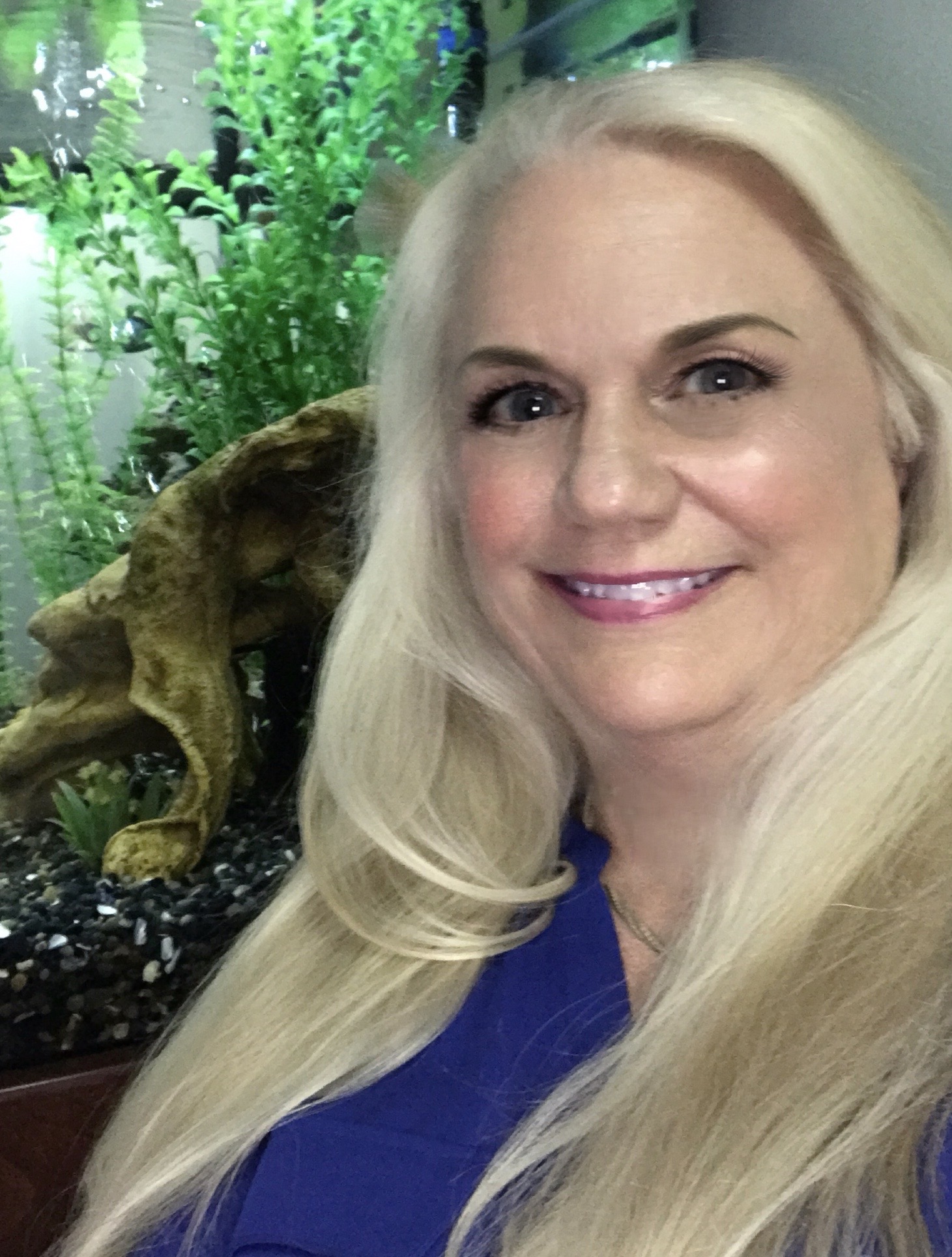 Sue Marshall, owner of Middle Way School of Hypnotherapy, in front of a tropical fish tank