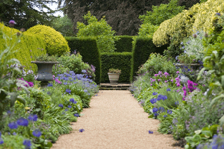 picture of an elaborate and well tended garden featuring purple hues and green